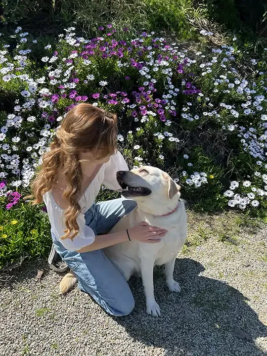 Picture of Jess with her dog Orion near some flowers